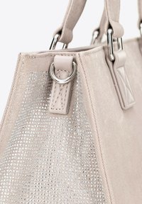 Beżowa torebka wykonana z fakturowanej kanwy, ozdobiona błyszczącymi cekinami. Srebrne akcenty i mocne materiałowe uchwyty.