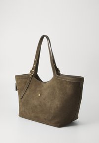 Smeđi suede torba za nošenje s glatkom teksturom, zaobljenim oblikom i zlatnim detaljima. Ima dva duga remena i minimalne šavove.