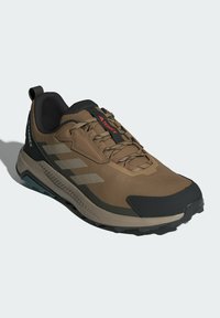 Brązowe buty trekkingowe Terrex z czarnymi akcentami, z siateczkową cholewką, wzmocnionym czubkiem i wytrzymałą podeszwą dla lepszej przyczepności.