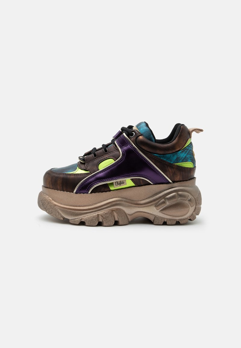 Chunky sneaker με παχιά μπεζ σόλα, μεταλλικό μωβ και καφέ επάνω μέρος, νέον πράσινες λεπτομέρειες, μαύρα κορδόνια και μπλε πατρόν στο κολάρο της φτέρνας.