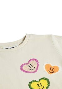 T-shirt beige in cotone con collo rotondo, con quattro cuori di paillettes nei colori rosa, giallo, arancione e verde.