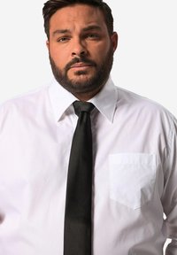 Camicia bianca con taschino sul petto e cravatta nera, dotata di colletto classico, texture liscia e taglio ben aderente.