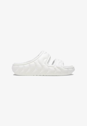 Chanclas blancas con un patrón texturizado y ondulado, diseño abierto en la parte delantera y trasera para mayor transpirabilidad. Hechas de un material suave y flexible.