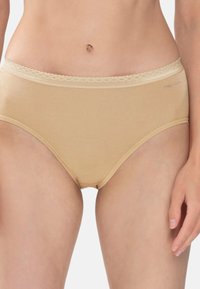 Beige bomullstrumpor med en midjeband som har spetsdetaljer. Tyget är slätt och designen har en klassisk passform. Minimal märkning är synlig.