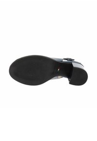 Suela de zapato de cuero, goma negra con una superficie texturizada. Ligera curva en el tacón. Sin marcas visibles ni elementos decorativos.