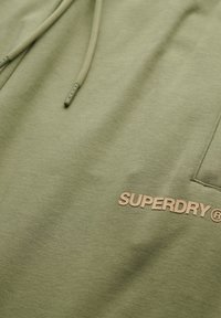 Olijfgroene hoodie gemaakt van zacht materiaal, met een voorzak en een reliëf "SUPERDRY" logo in tan op de linkerbovenborst.