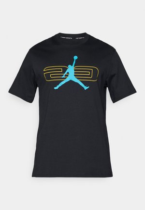 camiseta de algodón negra con un gran logotipo azul de "Jumpman" y un gráfico amarillo "23" en la parte delantera. Cuello redondo y mangas cortas.