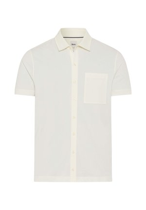 Camicia a maniche corte color crema con bottoni, colletto e taschino sul petto sinistro, distesa su uno sfondo bianco.