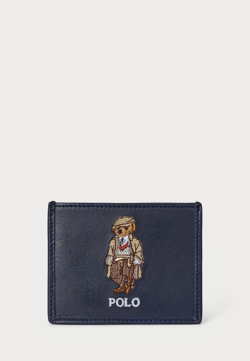 Jūras spēku ādas kredītkaršu turētājs ar izšūtu lāci beige tērpā un zilu kaklasaiti, kā arī "POLO" tekstu apakšā.
