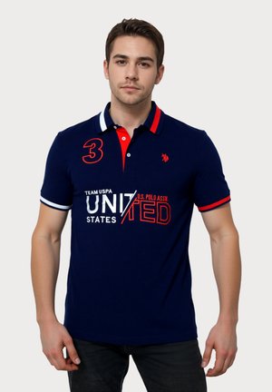 Polo marinero con cuello en contraste rojo, logo bordado y diseño de texto en blanco. Con mangas cortas y corte ajustado.