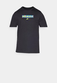 Svart t-shirt med kort ärm i bomull, med en färgglad "Just Do It" grafik och en liten Nike-logga i gult på framsidan.
