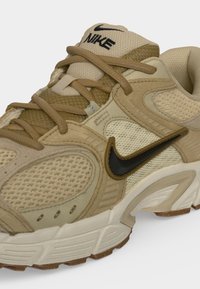 Μπεζ και καφέ αθλητικό παπούτσι Nike με μαύρο λογότυπο Swoosh, επενδυμένο πλεκτό μέρος και παχιά λευκή σόλα με υφή καφέ πάτου.