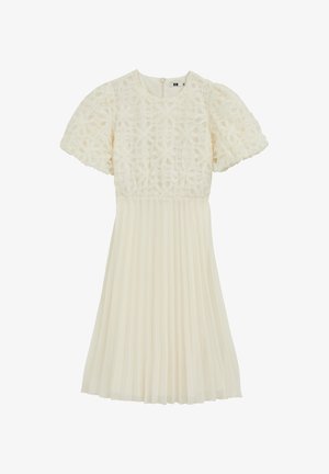 Robe crème plissée avec manches courtes bouffantes et corsage à texture florale. Dotée d'un col arrondi et d'une fermeture éclair au dos.