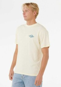 Bomulds T-shirt i lys gul med et blåt logo trykt på venstre bryst; rund halsudskæring og korte ærmer. Klassisk pasform.