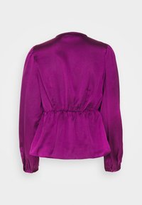 Blusa a maniche lunghe in satin fucsia con vita arricciata, colletto rotondo e polsini elasticizzati, che mette in evidenza una texture liscia.