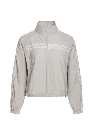 Giacca grigio chiaro con zip, collo alto, polsini elasticizzati e strisce di pizzo bianco sul petto e sulle maniche.