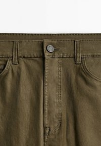 Olivgrüne Hose mit Knopfverschluss, Reißverschluss und Vordertaschen. Weicher, strukturierter Stoff mit sichtbaren Nähdetails.