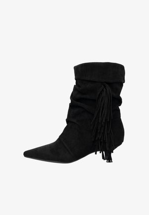 Stivaletto alla caviglia in camoscio nero con design scivolato, punta a mandorla e dettagli con frange sul lato. Tacco basso con una texture liscia.