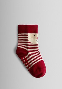 Calcetín a rayas rojas y crema con diseño de cara, tejido suave de punto, puño acanalado y puntos de agarre de goma en la suela.
