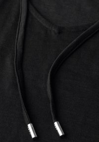 Tessuto nero con design a V e lacci neri, accentuati da puntali argentati. Texture liscia, vestibilità casual.