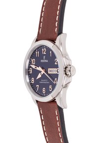 Festina kvarcinis laikrodis su tamsiai mėlynu ciferblatu, sidabriniu nerūdijančio plieno korpusu, rudena odine apyranke ir baltais siūlais. Datos rodymas trijų valandų pozicijoje.