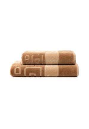 Due asciugamani beige e marroni piegati e impilati, con un motivo geometrico su sfondo bianco.