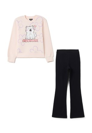 Sweatshirt rose clair avec graphique de chat et motif floral, associé à un pantalon évasé noir en matériau doux et flexible.