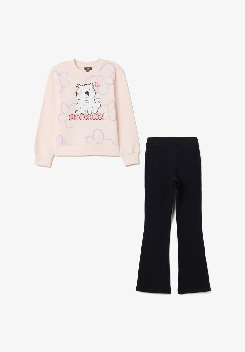 Sweatshirt rose clair avec graphique de chat et motif floral, associé à un pantalon évasé noir en matériau doux et flexible.