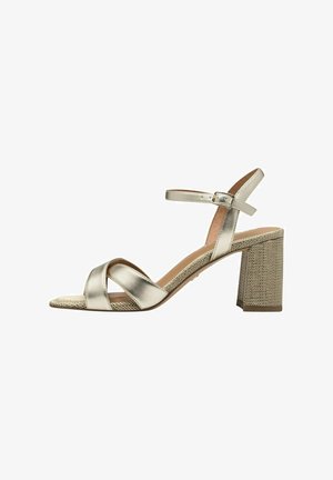 Kovové zlaté sandály na vysokém podpatku s křížovými pásky, strukturovaným blokovým podpatkem a páskem kolem kotníku s přezkou.
