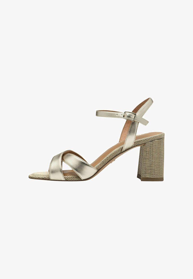Kovové zlaté sandály na vysokém podpatku s křížovými pásky, strukturovaným blokovým podpatkem a páskem kolem kotníku s přezkou.