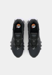 Nike Air Max sneakers in zwart en wit, met een gestructureerde bovenkant, een gevoerde tong en een zichtbare luchtunit in de zool.