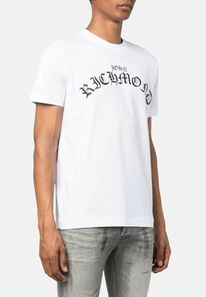 T-shirt bianca in cotone con testo nero che recita "JOHN RICHMOND" in un font audace e stilizzato. Collo a giro e maniche corte.
