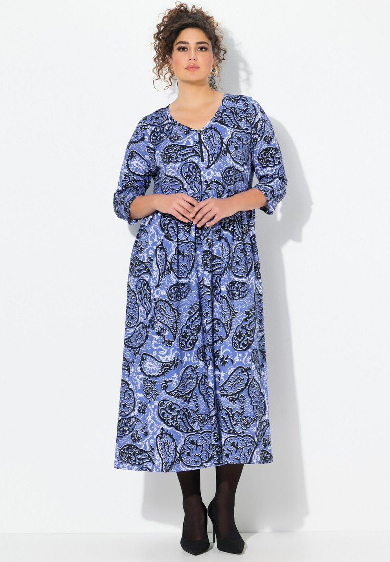 Vestido maxi en patrón de paisley azul y negro. Presenta mangas de tres cuartos, escote abotonado y una forma de A fluida.