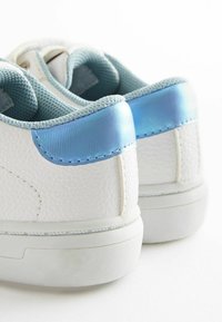 Sneaker bianche con una finitura in pelle testurizzata, dotate di un accento sintetico blu chiaro sul tallone e di una fodera in rete per il comfort.