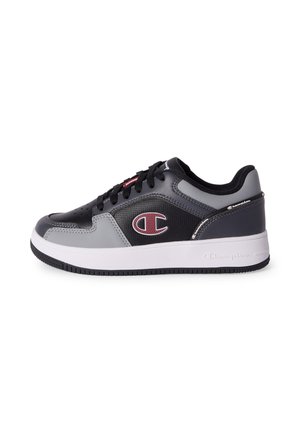 Czarno-szary niskoprofilowy sneaker z białą podeszwą, czarnymi sznurówkami i czerwono-białym logo Champion po boku.