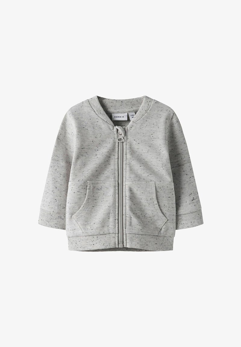 Szara kurtka na suwak wykonana z teksturowanej tkaniny z nakrapianym wzorem. Posiada dwie przednie kieszenie oraz ściągacze na mankietach i na dole.