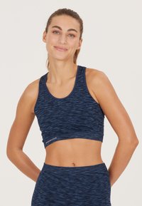 Marinblå sport-bh med en texturerad, melerad design, som har en rundad halsringning och en figurnära silhuett. Logodetaljer vid nederkanten.
