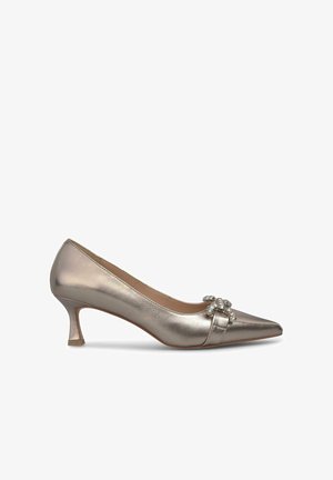 Escarpin argenté métallique à bout pointu, avec un détail en nœud et un accent décoratif en cristal. Dispose d'un petit talon carré.