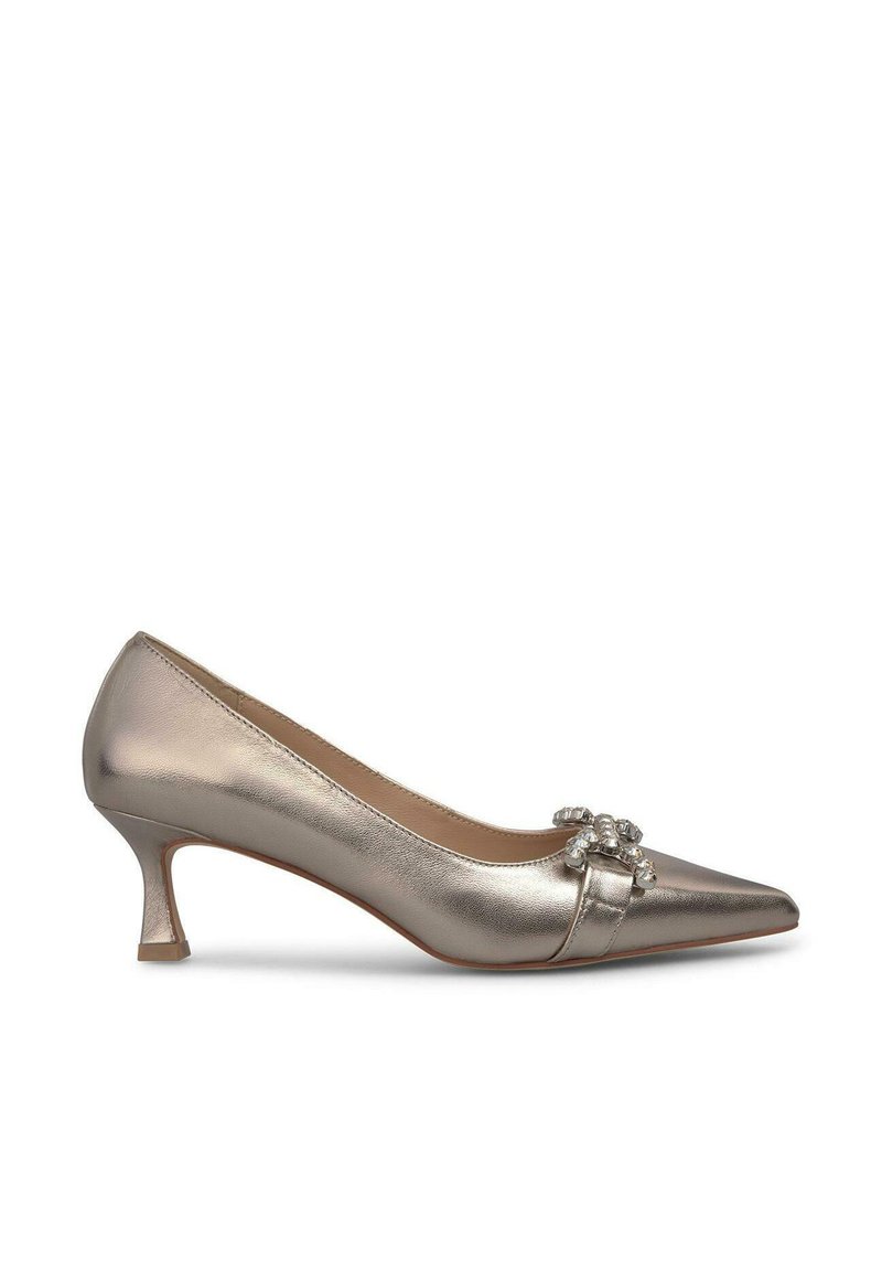 Scarpa con tacco alto di colore argento metallico, con punta a forma appuntita, dettaglio a fiocco e accentuazione di cristallo decorativo. Presenta un tacco piccolo e squadrato.