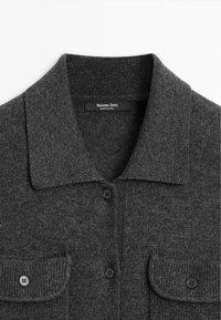 Cardigan en maille gris foncé avec col rabattable, boutons sur le devant et deux poches poitrine boutonnées, étiquette Massimo Dutti.