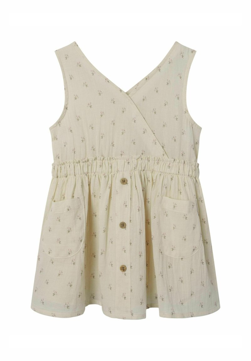 Robe sans manches à motif floral en tissu blanc cassé avec une taille élastique, deux poches latérales et des accents de boutons en bois.