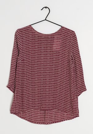 Maroon blouse met een ronde halslijn en driekwartmouwen, met een wit geometrisch patroon en een gladde, lichte stof.
