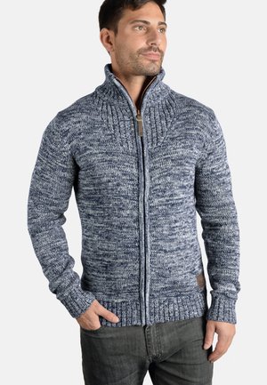 Suéter de punto de color navy con cuello alto, cremallera completa, puños acanalados y dobladillo; cuenta con una mezcla de colores azul claro y oscuro con un patrón texturizado.