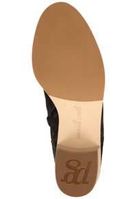 Suela de un zapato de vestir de cuero negro con una suela de goma marrón, marca "Paul Green" y logotipo "pg" en relieve en el talón.