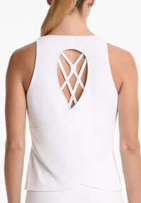 Top sans manches blanc avec une découpe ronde dans le dos présentant un design de bretelles croisées. Texture lisse avec une coupe décontractée et un ourlet arrondi.