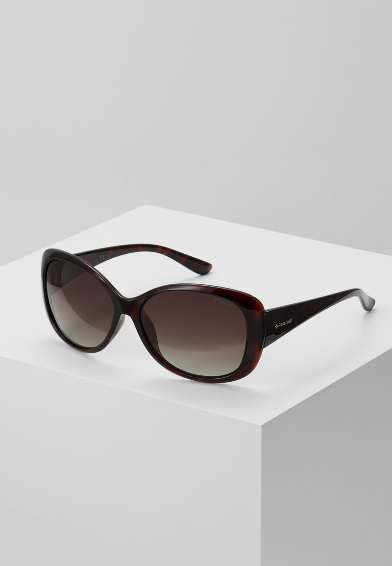 Tortoiseshell sunglasses with gradient lenses, wide frames, and sleek arms featuring a Polaroid logo. Textured finish enhances grip.