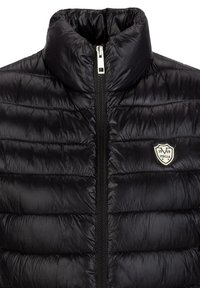 Schwarze Pufferjacke mit gestepptem Design, hohem Kragen, Vorderreißverschluss und einem kleinen Logobadge auf der linken Seite.