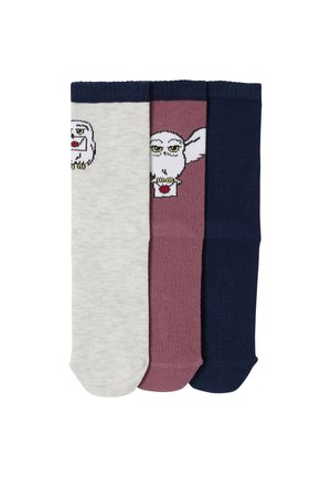 Drei gefaltete Socken in Grau, Mauve und Marineblau; die grauen und mauve Socken haben weiße Eulengesichter mit gelben Augen und roten Schnäbeln.