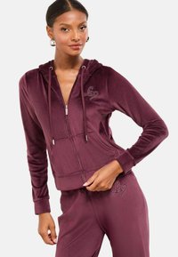 Bordová zipová mikina z mäkkého, sametového materiálu s klokaním vreckom, šnúrkami a akcentom s rhinestone logom na hrudi.