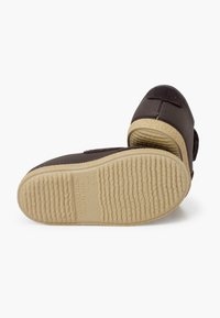 Pantofi din material brown cu talpă din cauciuc texturat. Prezintă o curea Velcro pentru o închidere ușoară. Fabricat în Spania. Mărimea 22 este embosată pe talpă.